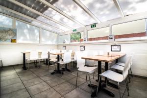 a dining room with tables and chairs and windows at Guesthouse Andrea in Reykjavík