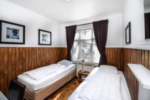 two beds in a room with a window at Guesthouse Aurora in Reykjavík