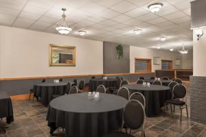 a room with black tables and chairs and a room with at The Plaza Hotel a Trademark Collection by Wyndham in Kamloops