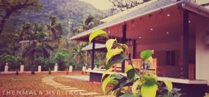 a building with a plant in front of it at Thenmala Heritage in Kolattupuzha