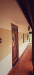un couloir vide avec une porte dans un bâtiment dans l'établissement Thenmala Heritage, à Kollam