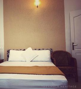 une chambre avec un lit avec une lumière sur le mur dans l'établissement Thenmala Heritage, à Kollam