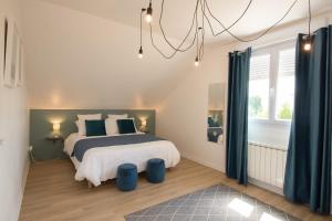 una camera da letto con un letto con pouf blu di Le Gîte du Puit des Granges a Fontaine-sur-Coole Altre 36 foto