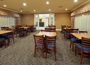 comedor con mesas y sillas de madera en Holiday Inn Express Corning, an IHG Hotel, en Corning