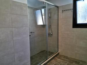 une douche avec une porte vitrée dans une salle de bain dans l'établissement RUSTIC SELF-INN, à Rhodes 27 autres photos