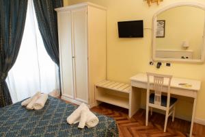 een kamer met een bed, een bureau en een spiegel bij Annette B&B in Rome