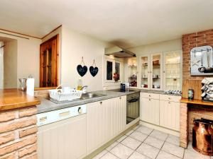 kuchnia z białymi szafkami i zlewem w obiekcie Spacious holiday home in Ouren with infrared sauna w mieście Burg-Reuland