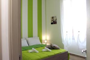 ein Schlafzimmer mit einer grün und weiß gestreiften Wand in der Unterkunft Charm Central in Reggio di Calabria