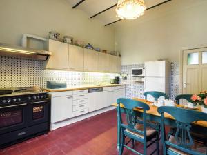 Il comprend une cuisine équipée d'une table, de chaises et d'une cuisinière. dans l'établissement Mansion in Beauplateau near Forest, à Gérimont