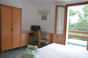 a bedroom with a bed and a desk with a computer at Guardia dei Mori in Carloforte