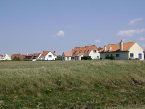 eine Reihe von Häusern auf einem Grasfeld in der Unterkunft Wonderful holiday home in Audinghen with garden in Audinghen