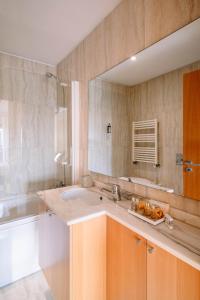 baño con lavabo y espejo grande en BBA Apartments Boavista - Casa da Música with Parking, en Oporto