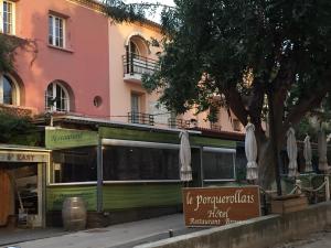 a restaurant with umbrellas in front of a building at Hôtel Le Porquerollais in Porquerolles