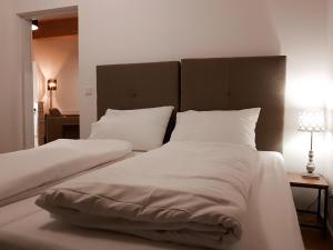 - une chambre avec 2 lits dotés de draps et d'oreillers blancs dans l'établissement Semmering Loft, à Semmering