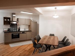 a kitchen and dining room with a wooden table and chairs at Semmering Loft in Semmering