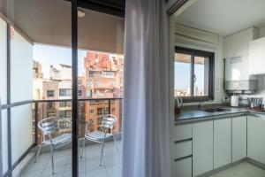 a kitchen with two chairs and a balcony with a view at AT Suites in Córdoba