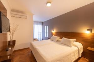 a bedroom with a white bed and a television at AT Suites in Córdoba +37 photos