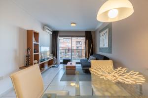 a living room with a table and a couch at AT Suites in Córdoba
