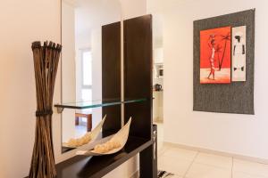 a glass display case in a living room with a painting at AT Suites in Córdoba