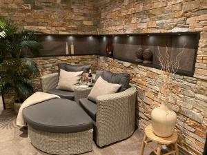 a patio with wicker chairs and a stone wall at Hotel De Vrouwe van Stavoren in Stavoren