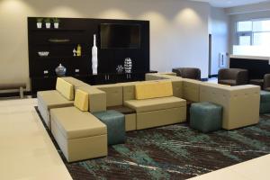 a lobby with a couch and chairs and a television at Holiday Inn Cincinnati North West Chester by IHG in West Chester