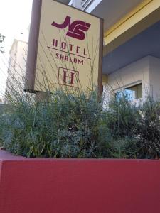 a sign for a hotel with plants in front of a building at Hotel Nordeste Shalom in Bragança