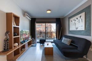 a living room with a couch and a tv at AT Suites in Córdoba