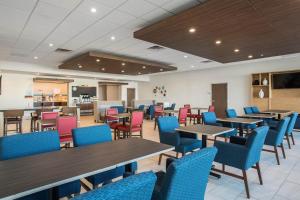 a dining room with tables and blue chairs at Holiday Inn Express & Suites Ludington by IHG in Ludington