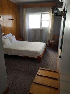 a hotel room with a bed and a window at Hotel Nordeste Shalom in Bragança
