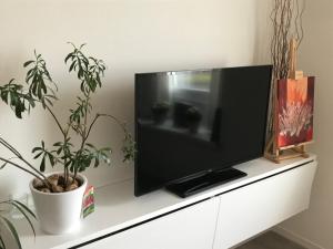 a flat screen tv sitting on top of a white dresser at Residentie Palace Zeebrugge in Zeebrugge