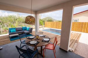 a patio with a table and chairs and a pool at Kas Honkie Tonkie in Kralendijk