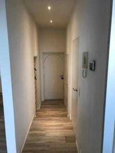 a hallway with white walls and a wooden floor at Residentie Palace Zeebrugge in Zeebrugge