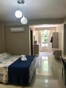 a bedroom with a bed with a blue blanket at Hotel Ibicui in Rosário do Sul