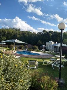 una piscina con 2 sillas y una sombrilla en Villa Camila en Villa Giardino