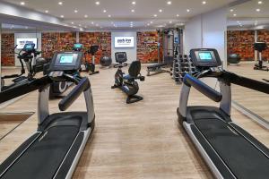 a gym with several treadmills and cardio machines at Park Inn by Radisson Berlin Alexanderplatz in Berlin