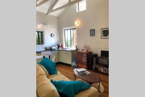 un salon avec un canapé et une table dans l'établissement Karma Cottage, à Maleny
