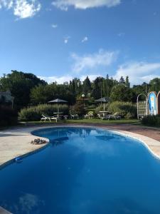 una gran piscina con parque infantil y mesas de picnic en Villa Camila en Villa Giardino