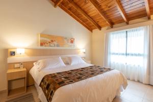 ein Schlafzimmer mit einem großen Bett und einem Fenster in der Unterkunft Altitud 720 Hotel, Aparts & Spa in Villa General Belgrano + 34 Fotos