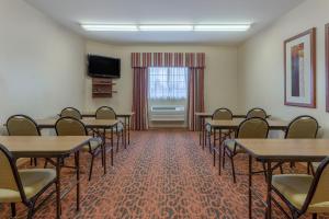 a room with tables and chairs and a television at Candlewood Suites Minot, an IHG Hotel in Minot