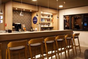 un bar en un restaurante con taburetes de madera en Holiday Inn Express - Kaiserslautern by IHG, en Kaiserslautern