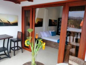 a bedroom with a bed and a table with a vase of flowers at Terrazas de San Agustin Hotel in San Agustín +34 photos