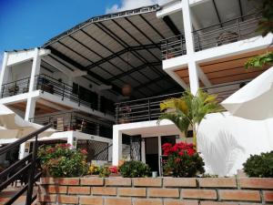 Un bâtiment blanc avec des fleurs devant lui dans l'établissement Terrazas de San Agustin Hotel, à San Agustín