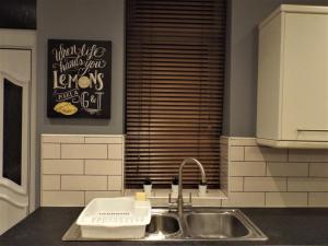 eine Küchentheke mit Spüle und Fenster in der Unterkunft Bronte Cinema Cottage At Haworth in Haworth + 20 Fotos