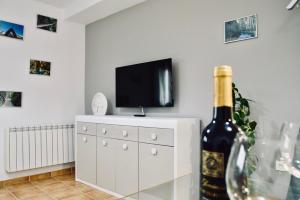 a bottle of wine sitting on a dresser next to a tv at Evaleta in Monachil