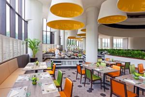 a restaurant with tables and chairs and windows at Holiday Inn Singapore Atrium by IHG in Singapore