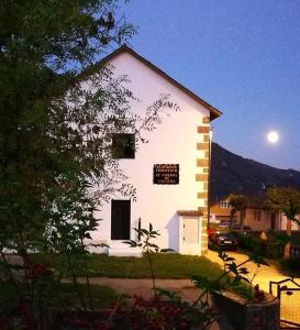 a white building with a moon in the sky at El cordal de laciana in Caboalles de Abajo