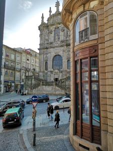 un grupo de personas caminando en una calle frente a un edificio en Clérigos Ville Porto Rooms, en Oporto
