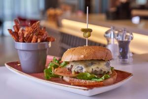 un panino su un piatto accanto a una tazza di patatine fritte di Holiday Inn Northampton West M1 Junc 16, an IHG Hotel a Northampton