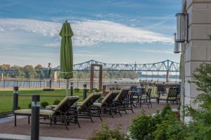 a patio with chairs and an umbrella and a bridge at Holiday Inn Owensboro Riverfront, an IHG Hotel in Owensboro