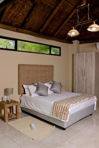 - une chambre avec un grand lit dans l'établissement Zoe Bush Lodge, à Pretoria